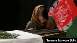 The wife of slain Japanese physician Tetsu Nakamura with the coffin of her husband at the Afghan military hospital in Kabul on December 6.