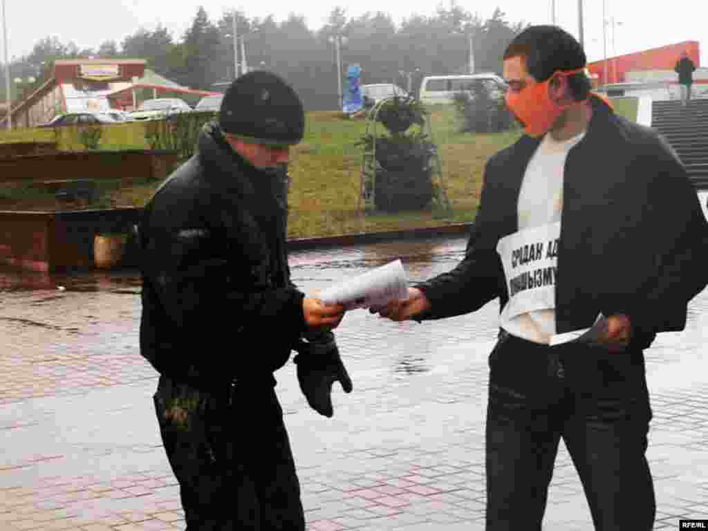 Каля ўнівэрмагу “Беларусь” зь дзясятак маладых людзей з марлевымі маскамі аранжавага колеру на твары і плякатамі на грудзях: “Сродак ад лукашызму” раздавалі мінакам буклеты пра беларускія нацыянальныя сымбалі.