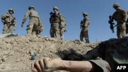 Американские военные проходят мимо тела афганского боевика. 8 сентября 2013 года.