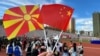 Eveniment cultural în China – un vizitator ține în mână steagurile Macedoniei de Nord și Chinei. 