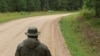 Un polițist de frontieră estonian și un soldat rus în zona „Cizmei Saatse” de la granița comună a celor două țări.
