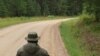 Эстонскі паліцыянт глядзіць на расейскага на памежнай дарозе, што праходзіць праз Саацкі бот