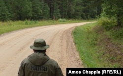 A Russian border guard (top right) looks towards his Estonian counterpart inside the Saatse Boot.