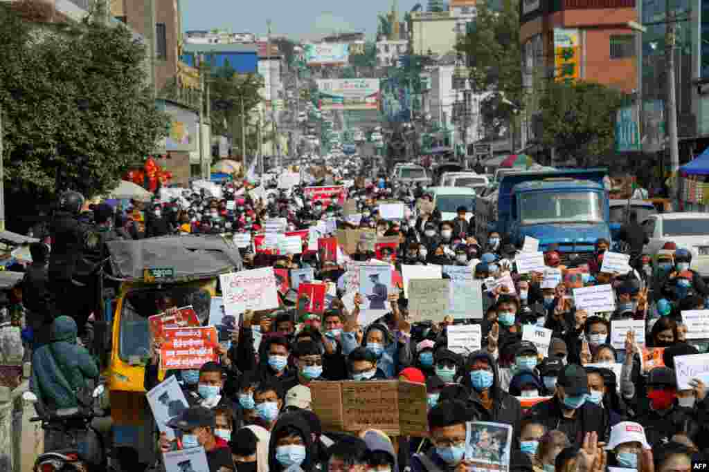 Oamenii participă la o demonstrație împotriva loviturii de stat militare din 1 februarie, de-a lungul unei străzi din orașul Muse din statul Shan, lângă granița China-Myanmar. (Photo by STR / AFP)