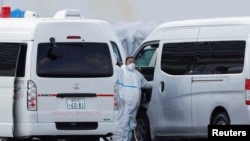 Japan -- Ambulance workers in protective gear prepare to transfer coronavirus patients from the cruise ship Diamond Princess at in Yokohama, February 12, 2020.
