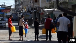 Palestinezët presin në radhë për t'u furnizuar me ujë në kampin e refugjatëve në Rafah, në jug të Rripit të Gazës. 15 tetor 2023. 