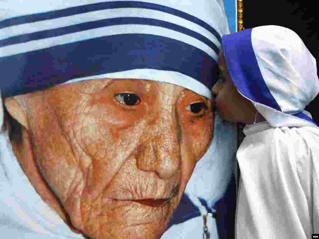 An Indian child dressed as Mother Teresa kisses her portrait during a tribute ceremony during her centenary birth celebrations in Bhopal, India, on August 26. Mother Teresa founded the order in 1950 and devoted herself to the cause of the poor, infirm, and the dying worldwide from her base in Calcutta. Mother Teresa died in 1997. Photo by Sanjeev Gupta for epa