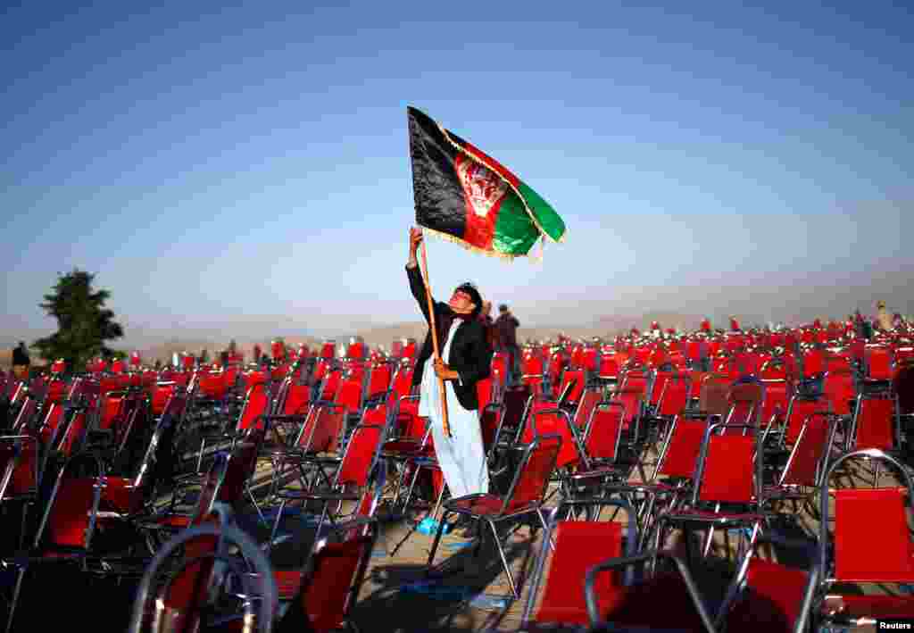 A supporter of Afghan presidential candidate Abdullah Abdullah holds aloft the country's flag after an election campaign rally in the Paghman district of Kabul. (Reuters/Ahmad Masood)