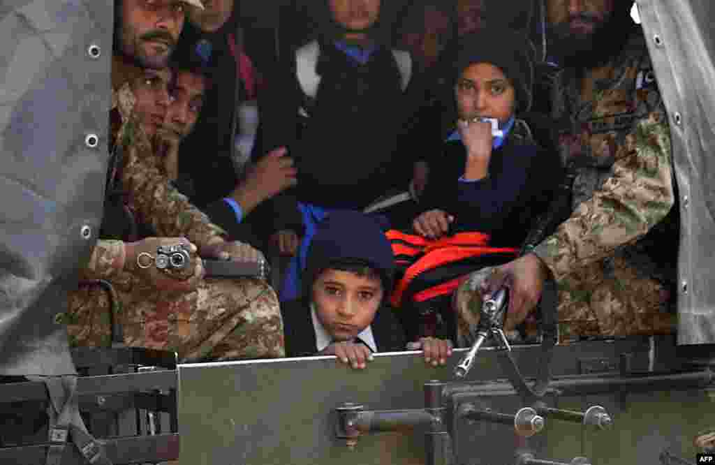 Pakistani soldiers transport rescued schoolchildren from the site of the attack.