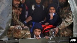 Пакистанские солдаты вывозят детей с места нападения на школу в Пешаваре. 16 декабря 2014 года.