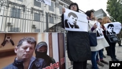 Ukrainian journalists hold placards depicting their colleague Roman Sushchenko during a protest to call for his in front of the Russian Embassy in Kyiv on October 6.