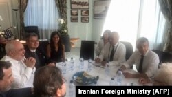 French President Emmanuel Macron and French Foreign Affairs Minister Jean-Yves Le Drian meet with Iranian Foreign Minister Mohammad Javad Zarif (2ndL) during a meeting in the city hall of Biarritz, August 25, 2019