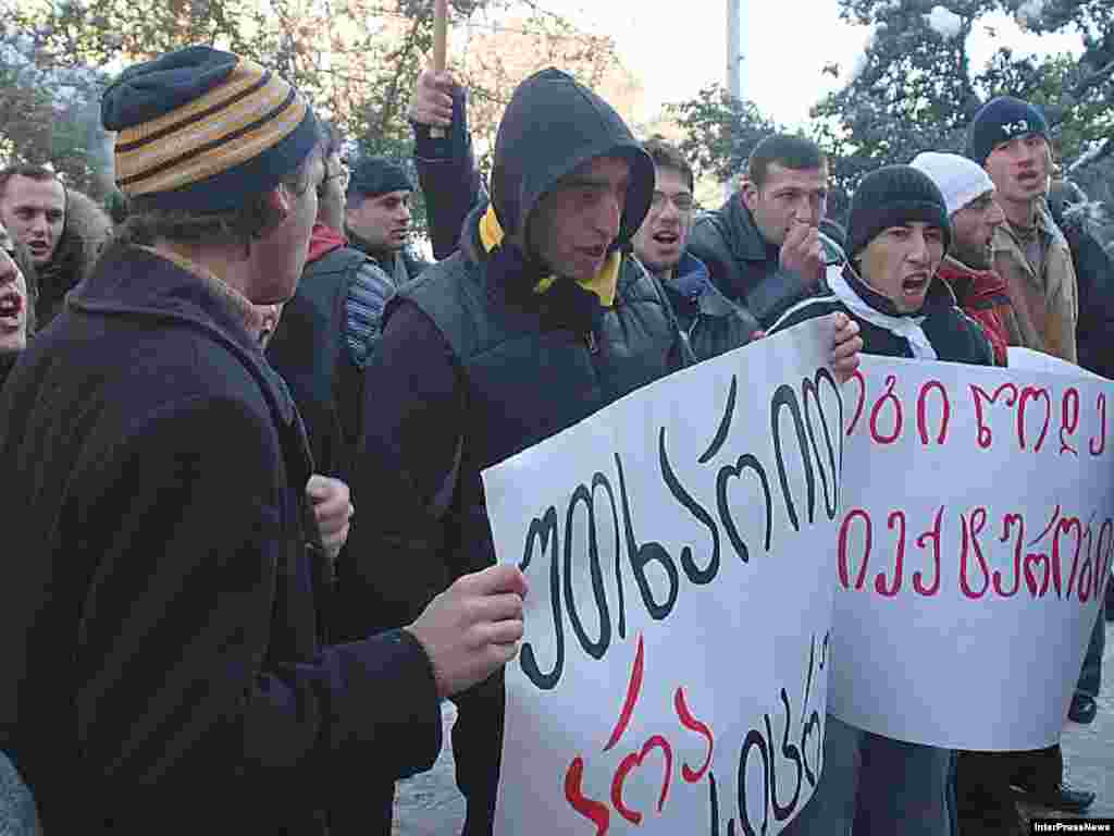 Members of the Georgian opposition hold a placard reading "We want thruth" and raise a finger to show the number of their candidate as they demonstrate in front TV headquarters 08 January 2008, in Tbilisi
