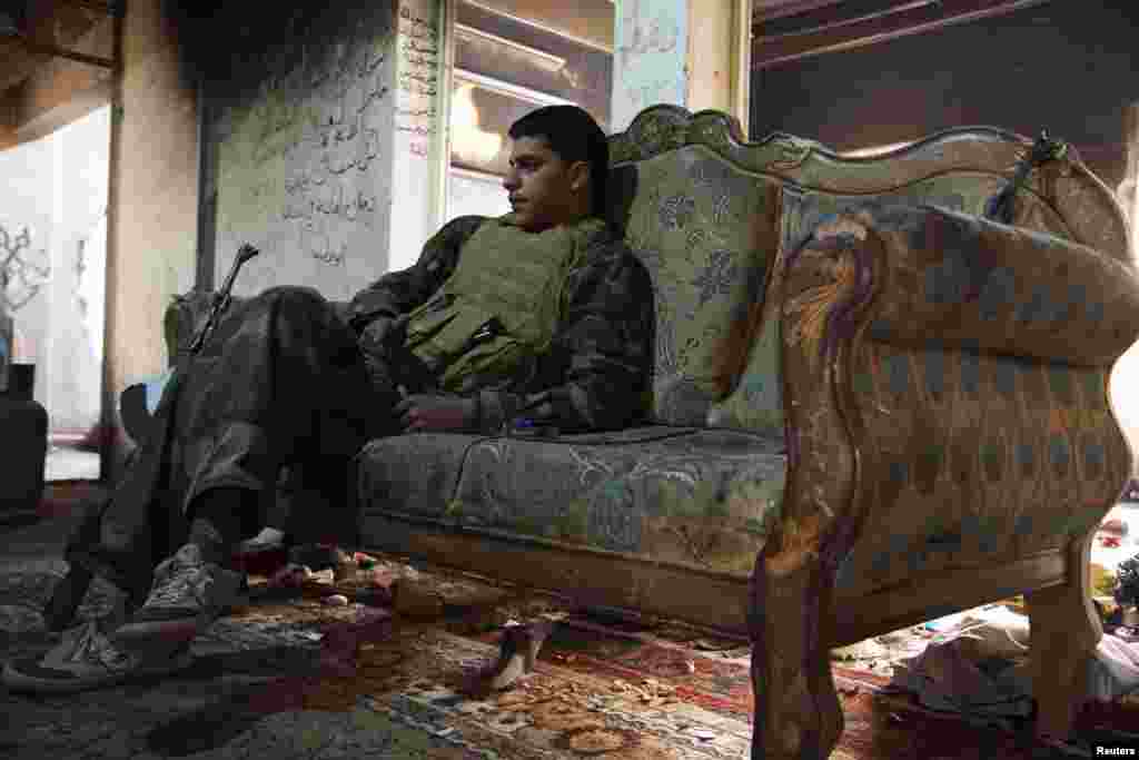 A Free Syrian Army fighter rests on a sofa inside a house in Deir al-Zor. (Reuters/Khalil Ashawi)