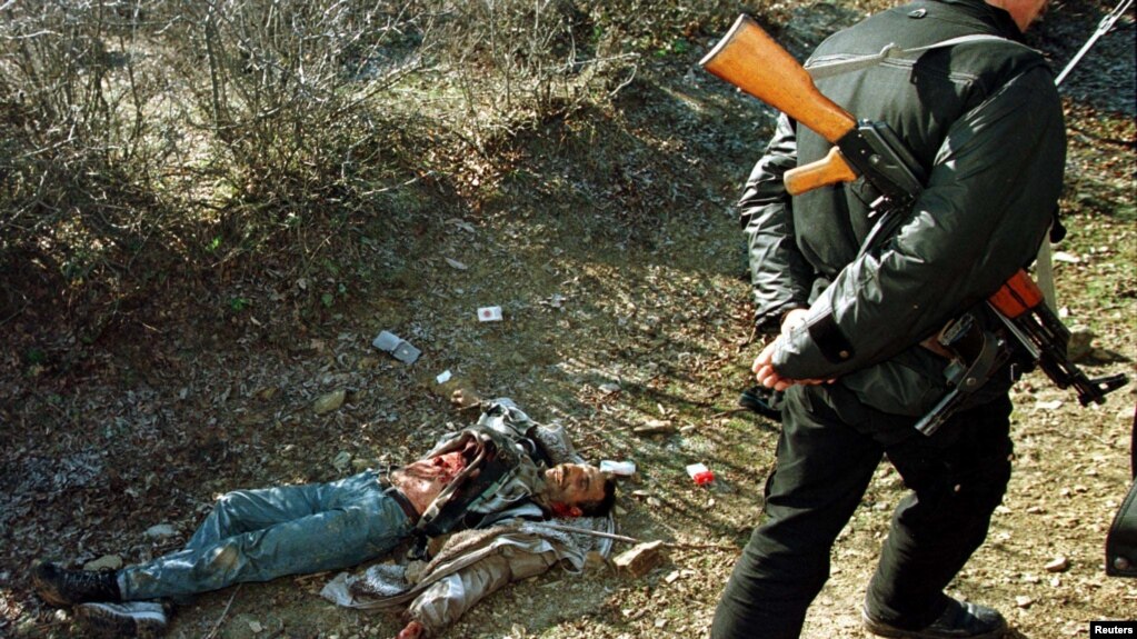 Kosovë: Një anëtar i Ushtrisë Çlirimtare të Kosovës duke kaluar pranë trupit të një fshatari nga Reçaku. Dyzet e pesë civilë shqiptarë u vranë nga forcat serbe më 15 janar 1999. Masakra e Reçakut konsiderohet një nga momentet kyç që ndikoi në ndërhyrjen e NATO-s kundër forcave serbe.Ukrainë: Një trup me duar të lidhura me copë të bardhë, i cili sipas banorëve u qëllua nga ushtarët rusë, shihet i shtrirë në rrugët e Buças në Ukrainë më 3 prill 2022. 458 civilë u vranë në Buça, sipas autoriteteve ukrainase. Disa prej viktimave ishin me duar të lidhura dhe, sipas zyrtarëve, ishin qëlluar nga afërsia.