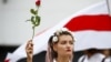 Жінка тримає квітку під час демонстрації опозиції на знак протесту проти результатів президентських виборів. Мінськ, 22 серпня 2020 року