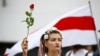 Жінка тримає квітку під час демонстрації опозиції на знак протесту проти результатів президентських виборів. Мінськ, 22 серпня 2020 року
