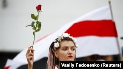 Женщина держит цветок во время демонстрации оппозиции в знак протеста против результатов президентских выборов. Минск, 22 августа 2020 года