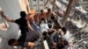 Disa njerëz duke u përpjekur ta nxjerrin trupin e vdekur të një kameramani palestinez që ishte i angazhuar nga agjencia e lajmeve, Reuters.