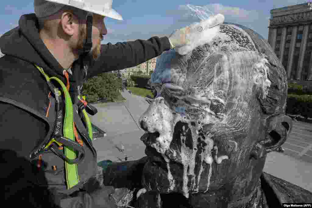 A worker washes a statue of the founder of the Soviet Union Vladimir Lenin on Moscow Square in Saint Petersburg. (AFP/Olga Maltseva)