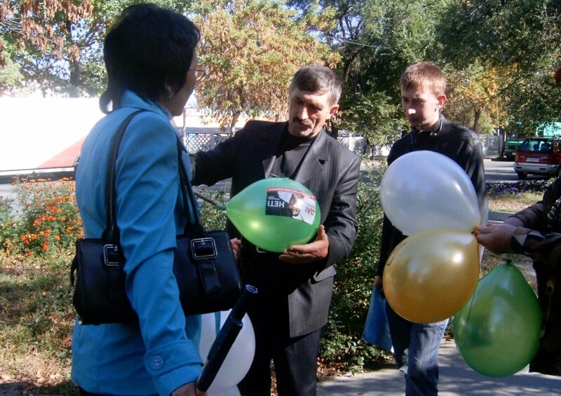 Активисты «Азата» раздают прохожим шары с фотографией осужденного правозащитника Евгения Жовтиса. Талдыкорган, 6 октября 2009 года.
