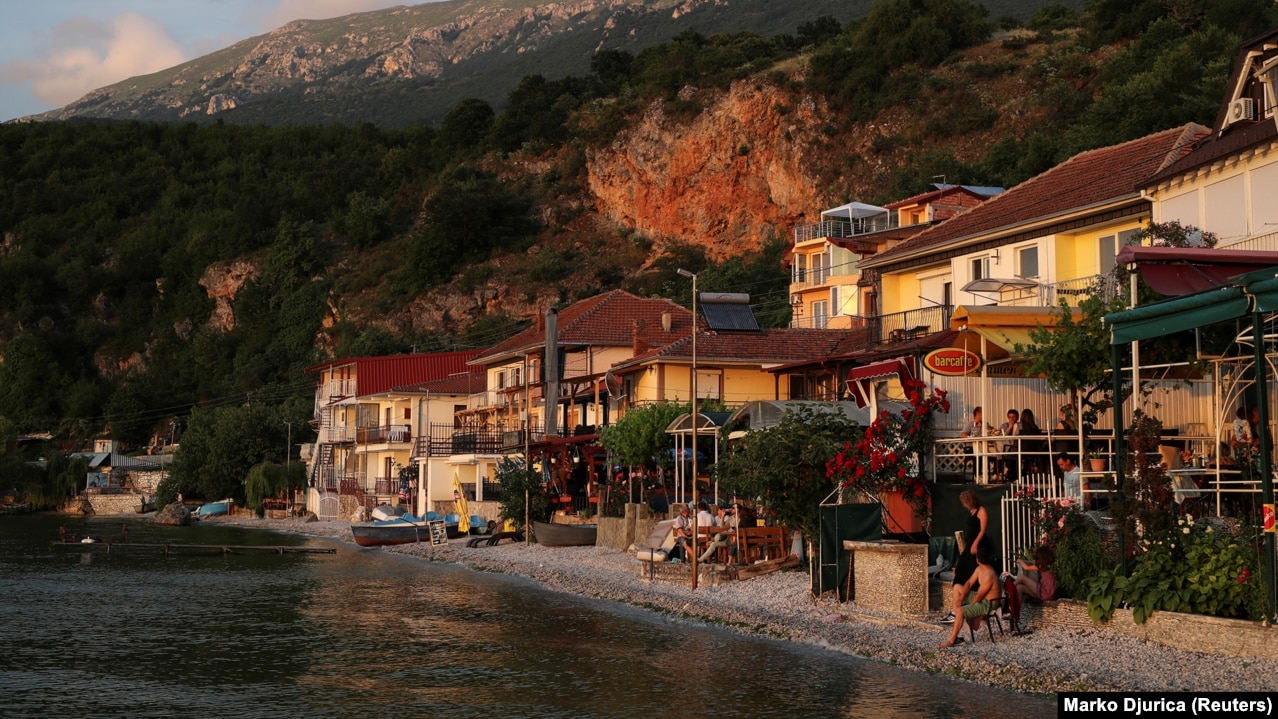 Луѓето седат во рестораните покрај Охридското езеро во селото Трпејца.