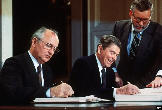Lideri sovjetik Mikhail Gorbatchev dhe presidenti amerikan Ronald Regan duke nÃ«nshkruar Traktatin pÃ«r ArmÃ«t bÃ«rthamore. Uashington, 8 dhjetor, 1987.