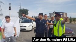 Водители жалуются дорожному полицейскому на заторы из-за перекрытых улиц. Алматы, 18 августа 2018 года.