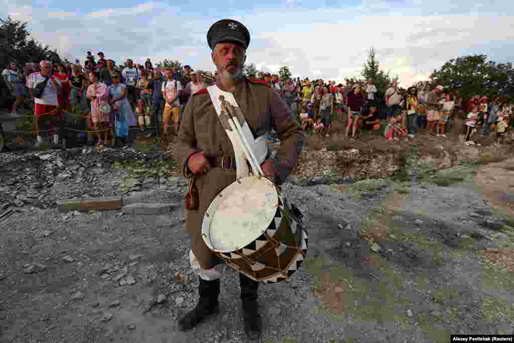 Crowds of spectators and an actor wait for the action to begin. Work on the park began shortly after the Russian occupation and annexation of Crimea in 2014. 