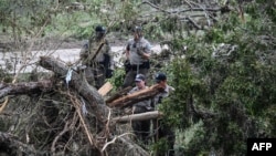 Căutând supraviețuitori pe malul râului Guadalupe la Kerrville, Texas, pe 6 iulie, la două zile după inundațiile locale dezastruoase. 