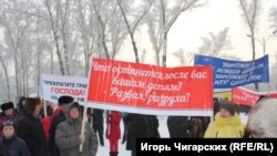 Участник митинга за отставку главы Республики Хакасия с транспарантом, 16 декабря 2017 года