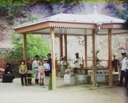 Відвідувачі джерела в Боржомі між 1905 і 1912 роками. Деякі в групі тримають чашки в руках після того, як випили «лікувальну» воду, якою місто всесвітньо відоме