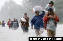 Местные жители покидают дома из-за наводнения, вызванного ураганом «Харви». Бтюмонт Плейс, 28 августа 2017 года.