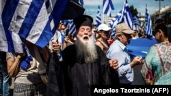 A Greek Orthodox priest takes part in a protest against a compromise with Macedonia in the dispute over its name.