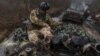 A Ukrainian service member rides atop of an infantry fighting vehicle near the frontline town of Bakhmut