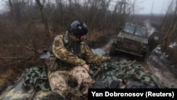 Un soldat al forțelor ucrainene pe un vehicul al infanteriei în apropierea orașului Bahmut