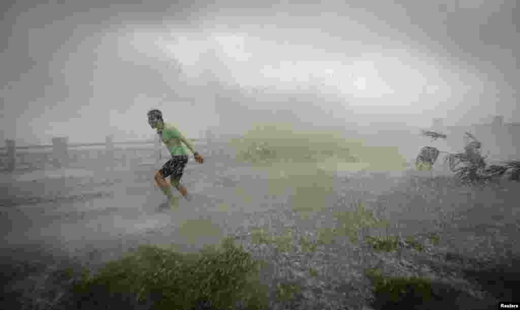 A man runs way from a wave at a beach in Hainan Province, China, as Typhoon Sarika hit the mainland. (Reuters)