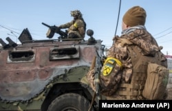 Українські військовослужбовеці оглядають знищений російський піхотний броньований автомобіль «Тигр» після бою в Харкові, 27 лютого 2022 року