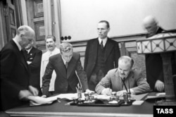 Міністр закордонних справ СРСР В'ячеслав Молотов (праворуч, сидить) підписує пакт Молотова-Ріббентропа. Третій ліворуч – голова уряду СРСР Йосиф Сталін. Москва, 23 серпня 1939 року