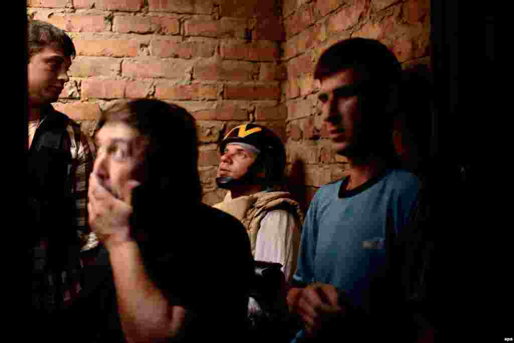 A journalist of TV Belsat (2nd right) and locals stand in a basement during a mortar barrage in the eastern Ukrainian village of Semyonovka, outside Slovyansk, on May 26. (epa/Jakub Kaminski)