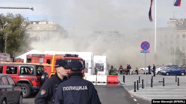 Oficerë dhe zjarrfikëse pranë një kampi tendash të mbështetësve të Qeverisë para Kuvendit serb.