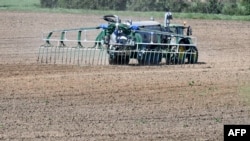 A farmer spreads fertilizer before sowing corn in Brulon, western France. (file photo)