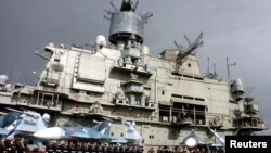 Naval personnel stand in front of Russian aircraft carrier "Kuznetsov" at the Mediterranean port Syrian city of Tartous in January.