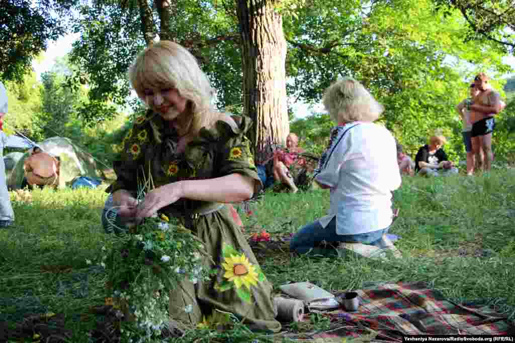 A woman weaves a wreath out of grass and flowers that carry symbolic meaning. According to folk beliefs, plants collected on Ivan Kupala Night hold special powers.&nbsp; &nbsp;
