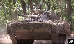 Russian troops drive an armored personnel carrier toward Ukrainian positions near Vuhledar.