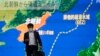 Pješak prolazi pored velikog TV ekrana na kojem je vijest o tome kako je Sjeverna Koreja lansirala balističke rakete u Japansko more, Tokio (19. oktobar 2021.)