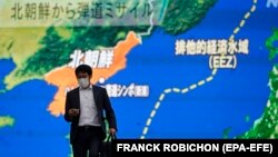Pješak prolazi pored velikog TV ekrana na kojem je vijest o tome kako je Sjeverna Koreja lansirala balističke rakete u Japansko more, Tokio (19. oktobar 2021.)