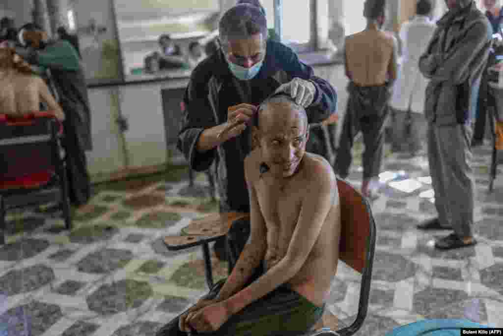 На зависник му ја бричат главата во одделот за детоксикација на болницата Авицена во Кабул, 16. Октомври 2021 година.