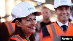 Anne Hidalgo, Párizs polgármestere Emmanuel Macron elnökkel együtt látogatta meg a saint-oueni olimpiai falu építését Párizs külvárosában 2021. október 14-én