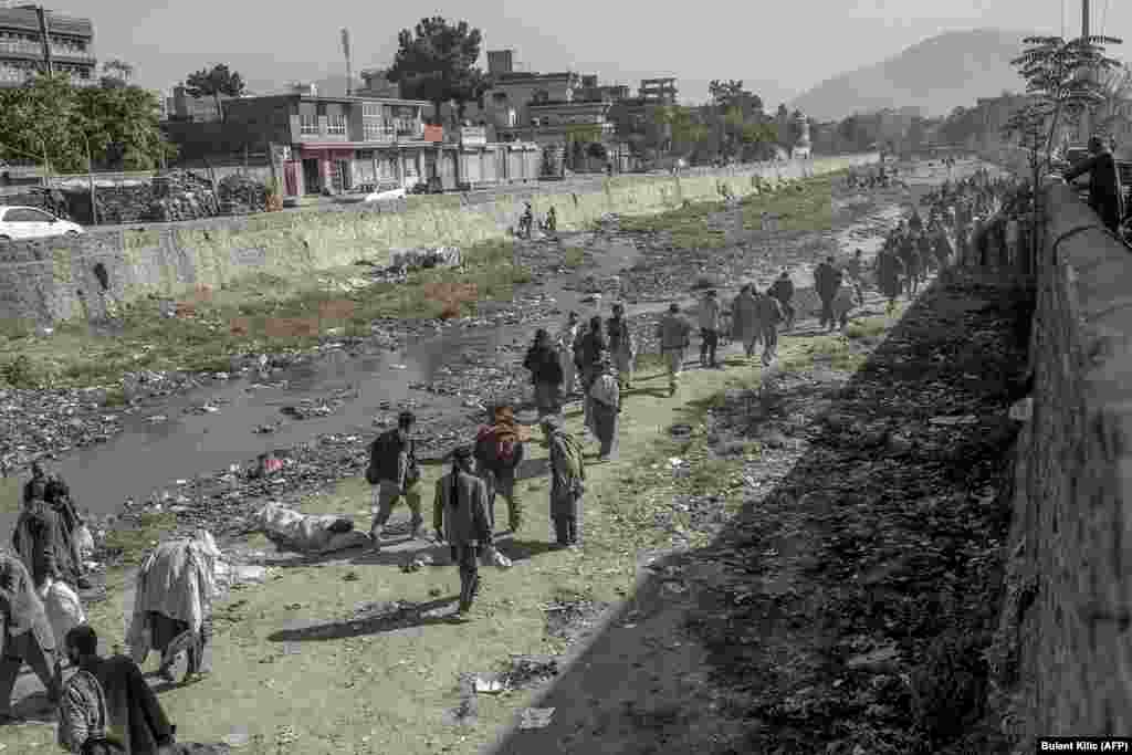 Drug users run from Taliban members who are trying to detain and transfer them to the Avicenna Medical Hospital for Drug Treatment in Kabul on October 16.